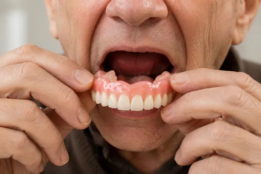 Dental professional holding a set of complete dentures at Edmonds Dental Studio in Edmonds Washington.